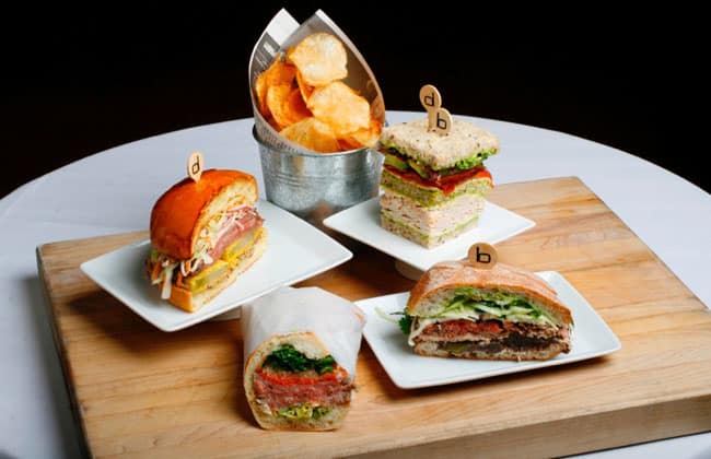 Lighter fare is on the meetings menu at The Brazilian Court Hotel in Palm Beach. Clockwise from top right: CBPB Turkey Club with oven-roasted tomato, sprouts and basil vinaigrette; Jimmy's BLT, with house-smoked lean beef brisket, green tomato and lettuce slaw; Bahn Mi, with pickled carrots, daikon and mint; and Mexican Torta, with adobo pork, cilantro and roasted peppers.