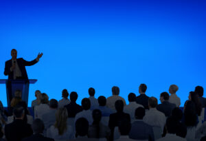 corporate speaker giving talk to large audience