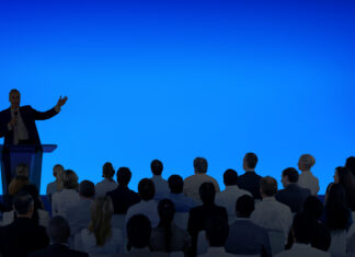 corporate speaker giving talk to large audience